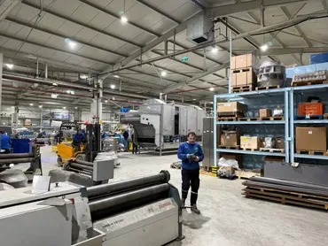 Fabrication hall with a plate rolling machine and material racks